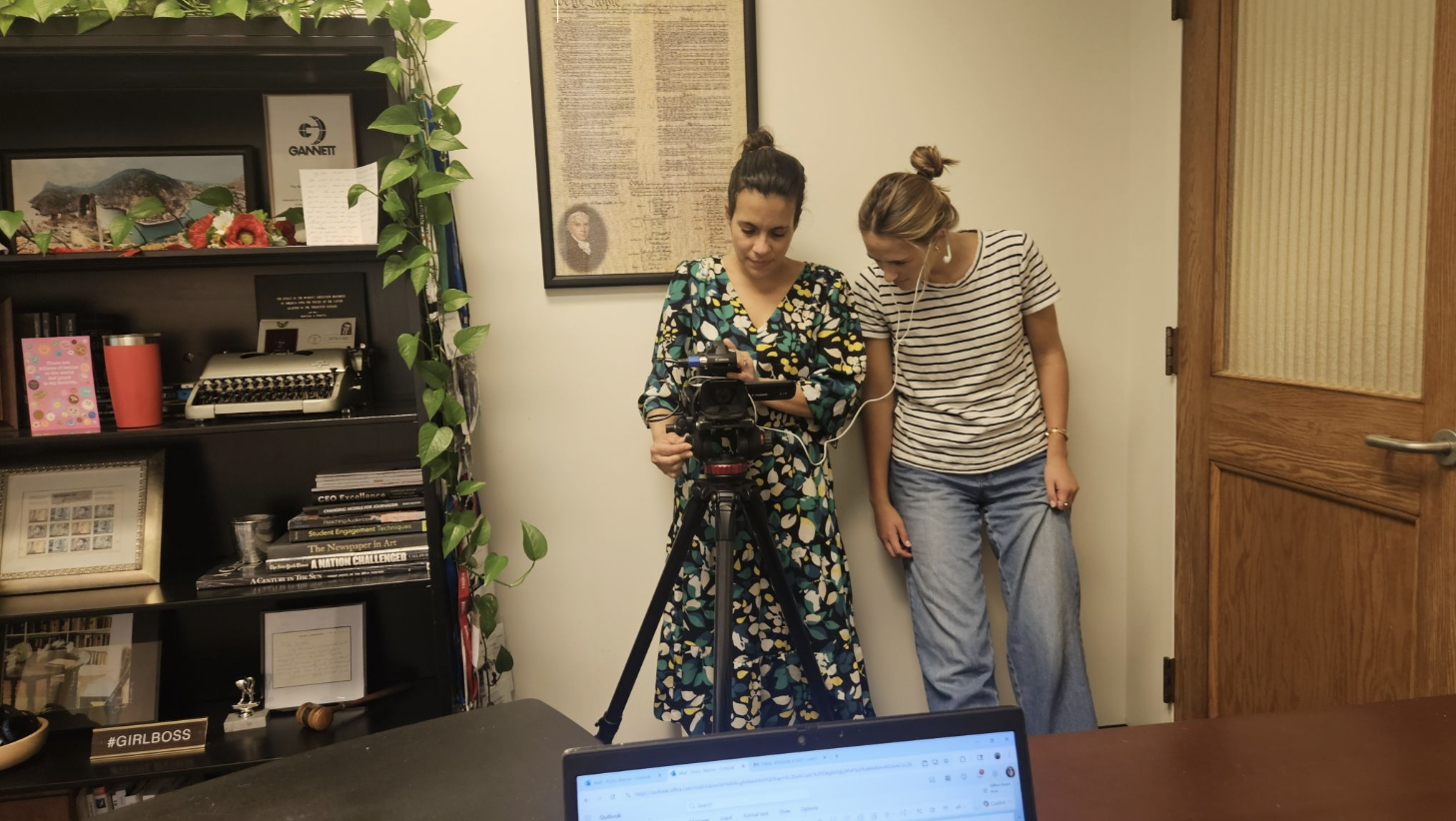 Two women looking over a camera